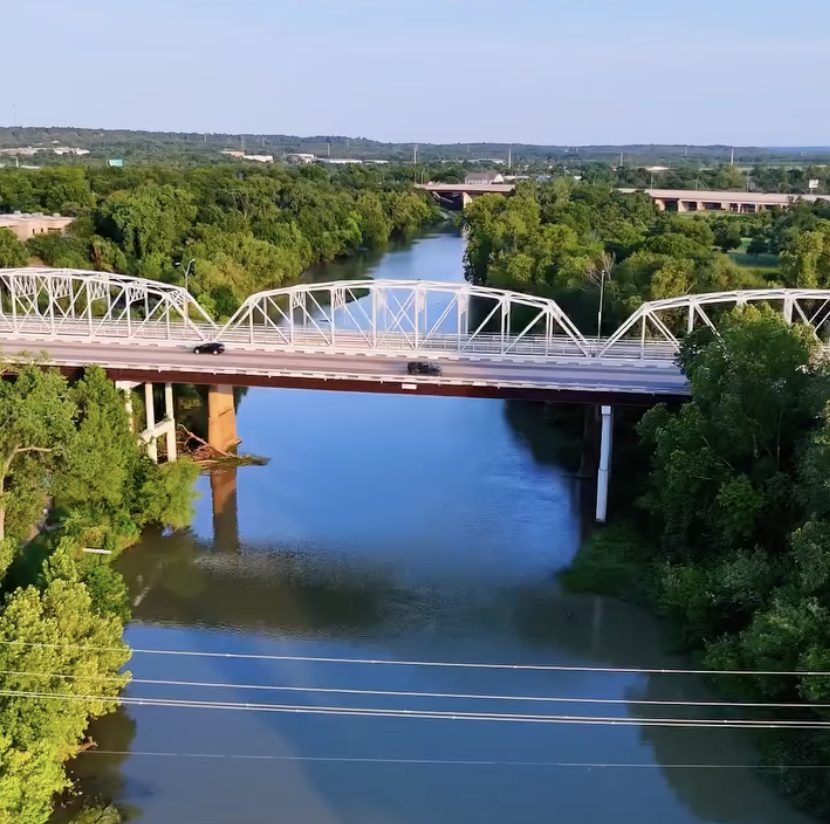 Aerial view of the historic iron truss bridge over the Colorado River in Bastrop